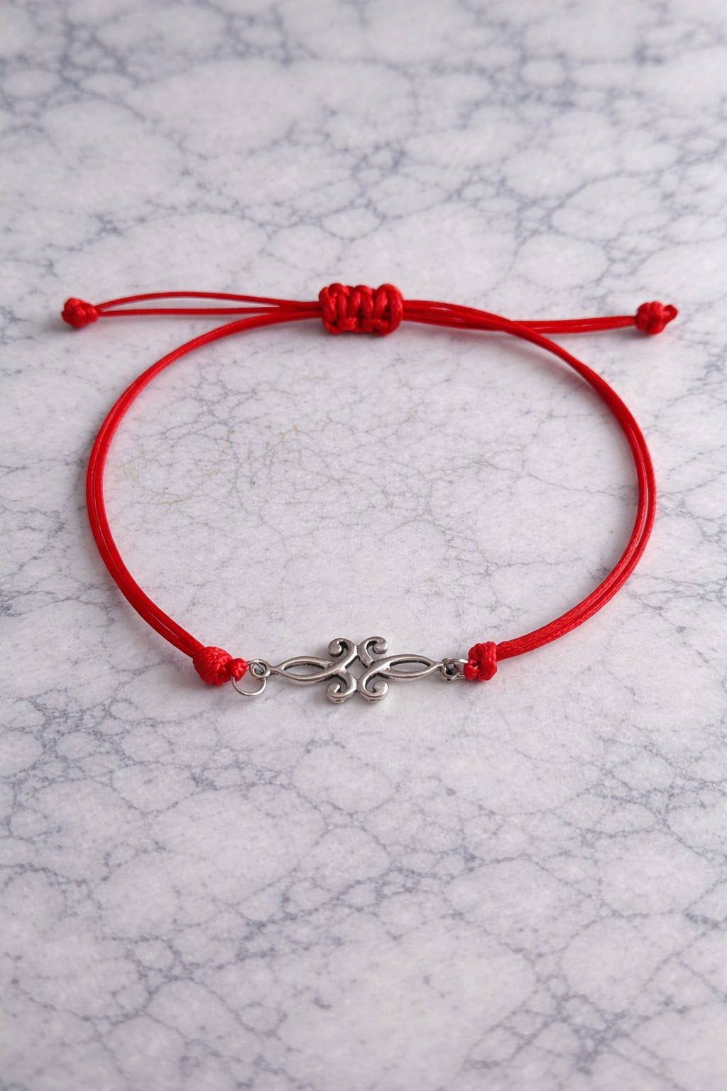 Bracelet avec un petit arabesque en métal codon rouge