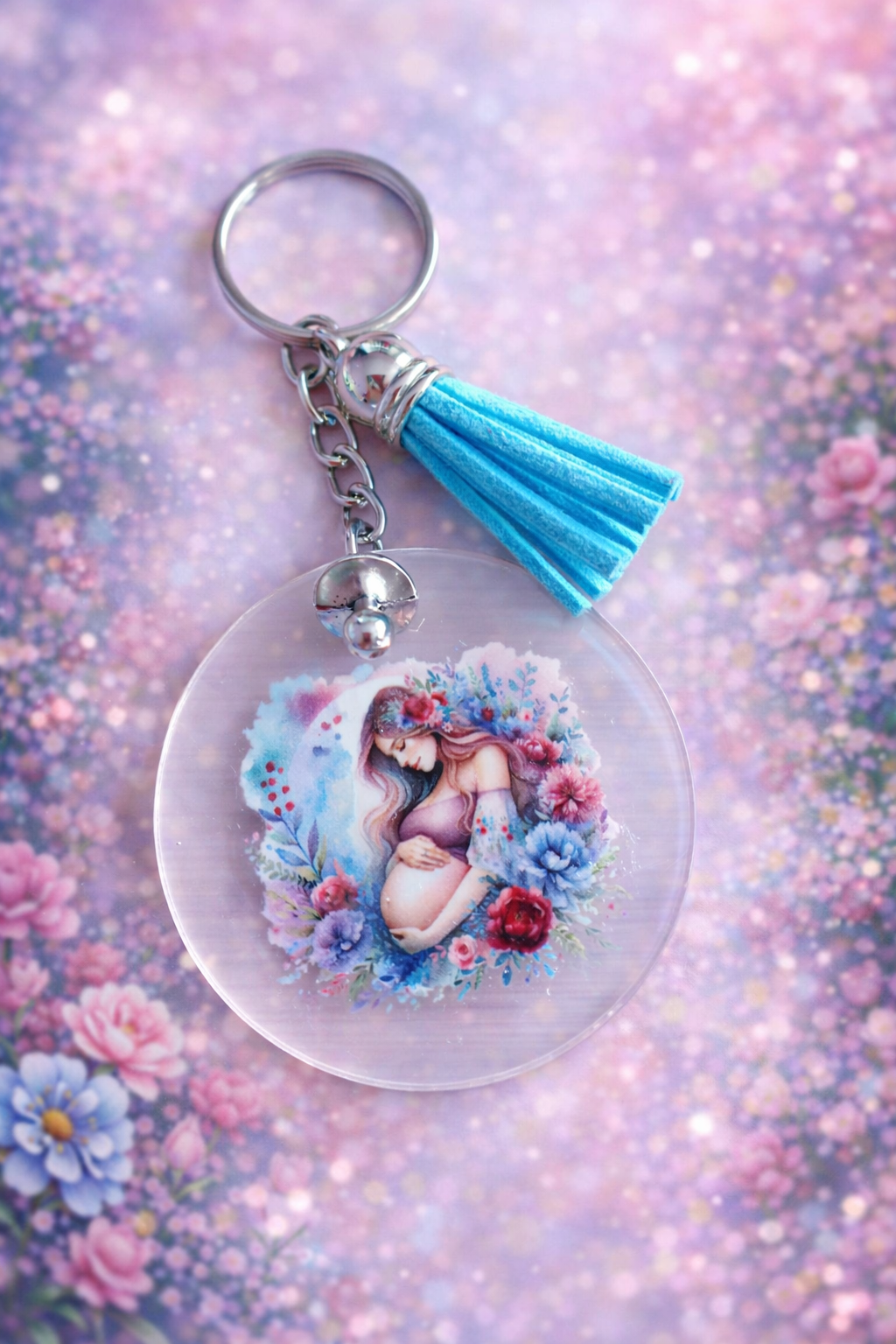 Porte clés avec une image de femme enceinte et un pompon bleu et aussi une tétine en métal