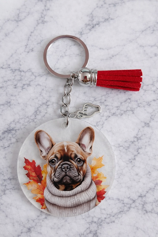 Porte clés avec une tête de chien un pompon rouge