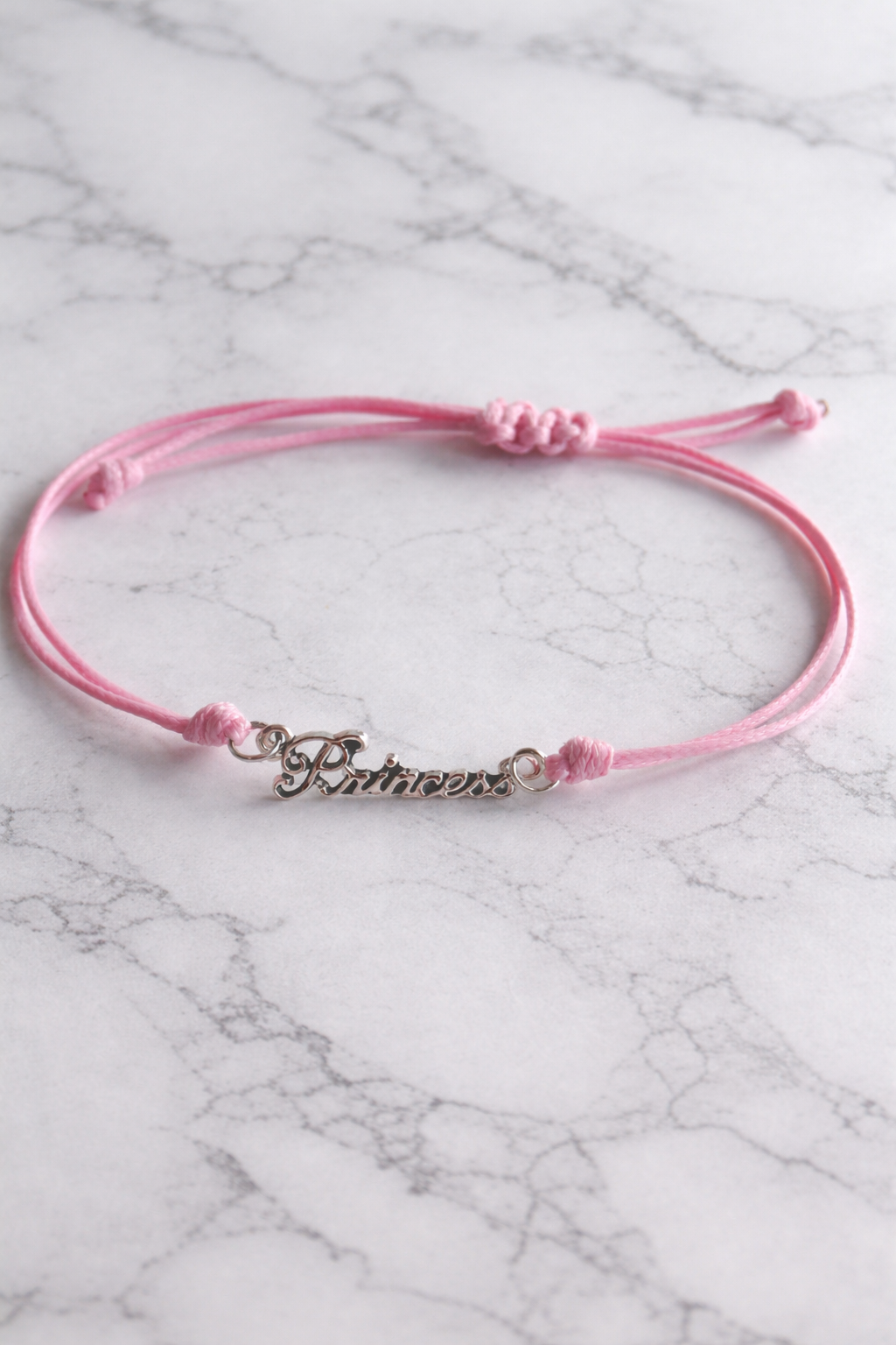 Bracelet réglable en cordon rose . Convient à la plupart des poignets.