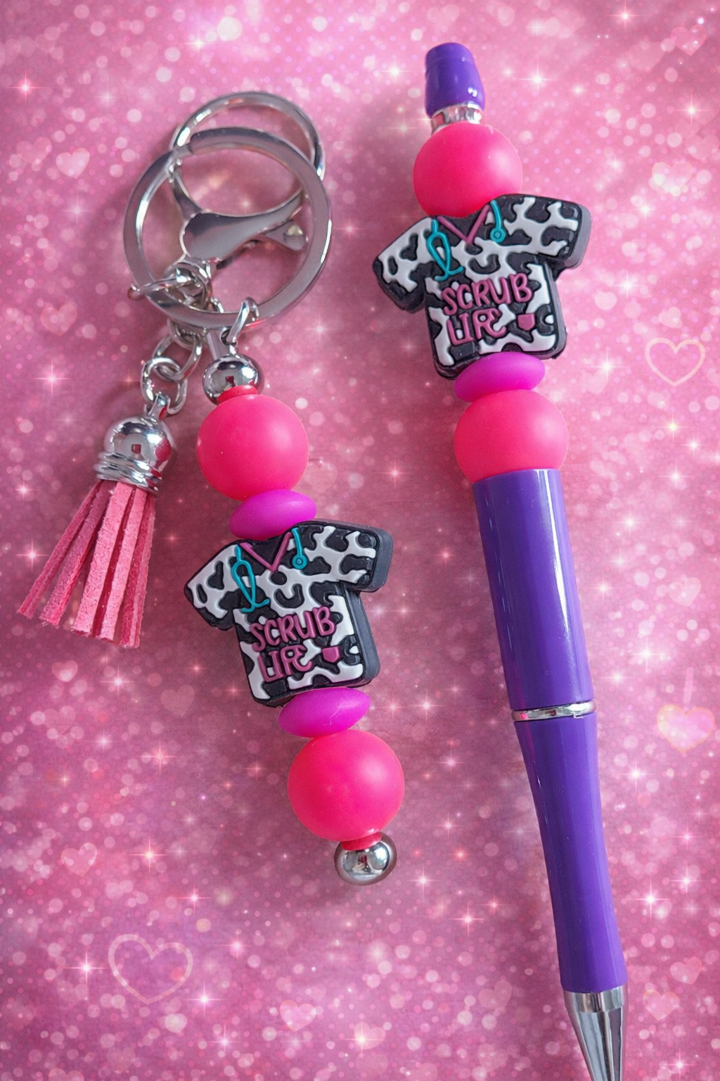 Stylo avec porte clés il a des perle en silicone et aussi un pompon le porte clés en métal 